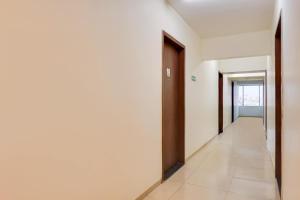 a corridor of an empty room with two doors at Super Townhouse Lohegaon Near Pune Airport Formerly Landmark Regency in Pune