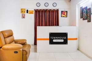 a waiting room with a chair and a television at Super Townhouse Lohegaon Near Pune Airport Formerly Landmark Regency in Pune