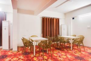 a room with tables and chairs and a curtain at Super Townhouse Lohegaon Near Pune Airport Formerly Landmark Regency in Pune
