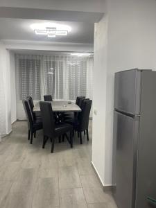 ein Esszimmer mit Tisch, Stühlen und Kühlschrank in der Unterkunft Silent Hills in Moieciu de Jos