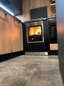 a kitchen with a oven with a fire in it at Maso Walter in Pradellan +16 photos