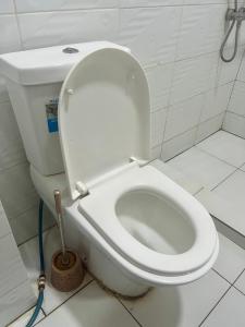 a white toilet in a bathroom with a plunger at KiGALI CITY COMFORT ACCOMMODATION in Kigali +18 photos