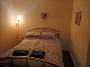 a bedroom with a bed with two towels on it at Noglas in Ammanford