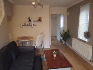 a living room with a couch and a table at Noglas in Ammanford