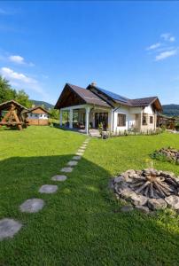a house with a stone path in front of a yard at Casa Mia in Câmpulung Moldovenesc