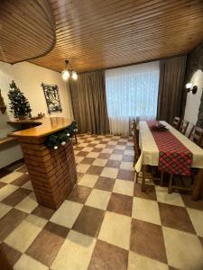 a dining room with a table and a checkered floor at Артемів двір in Slavske