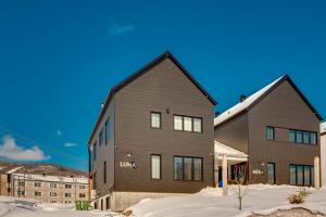a large house in the snow in front of buildings at Luna - 5 chambres - 14 personnes in Saint-Férréol-les-Neiges