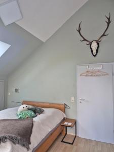 a bedroom with a bed with a teddy bear on it at Ferienwohnung mit Stil in Georgenthal