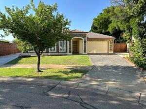 a house with a tree in front of a driveway at Solara Retreat Mildura in Mildura