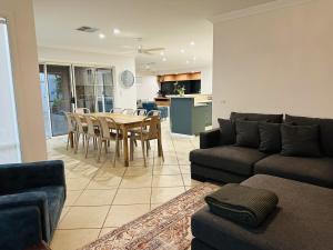 a living room with a couch and a table and chairs at Solara Retreat Mildura in Mildura