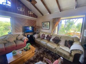 a living room with a couch and a tv at La Casona del Trancura in Pucón