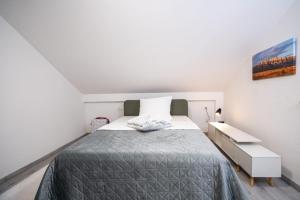 a white bedroom with a bed and a dresser at Fort Vista in Knin
