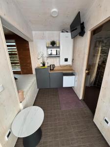 a small kitchen in a tiny house with a table at EstBerg Tartu Glasshouse with Sauna in Tartu