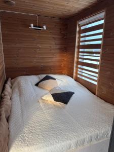 a bedroom with a bed in a wooden room at EstBerg Tartu Glasshouse with Sauna in Tartu +4 photos