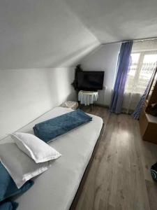 a bedroom with a bed and a flat screen tv at Casa de sub pădure in Valcea