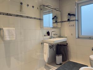 a white bathroom with a sink and a mirror at ZU HAUSE Pfalz in Bad Dürkheim +36 photos