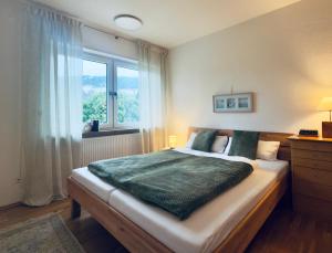 a bedroom with a large bed with a window at ZU HAUSE Pfalz in Bad Dürkheim
