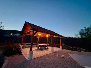 a gazebo with a table and chairs on a patio at Villa Billubium - Dalmatian Stone House with Private Heated Pool in Zovko
