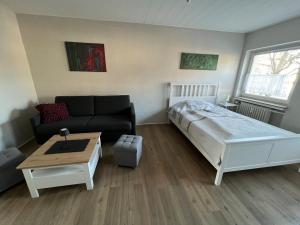 a bedroom with a bed and a couch and a table at Über dem Dörpken in Wuppertal
