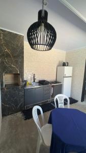 a kitchen with a table and chairs and aendant light at Apartamento 4 - Refúgio do Descaso in São Francisco do Sul