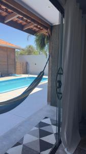 a hammock hanging from the side of a house with a pool at Apartamento 4 - Refúgio do Descaso in São Francisco do Sul +5 photos
