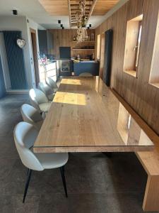 a large wooden table with white chairs in a room at Maso Walter in Pradellan