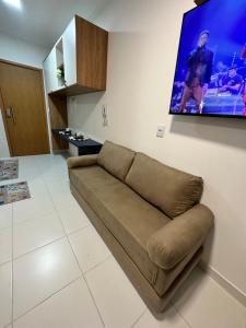 a couch in a living room with a tv on the wall at Mana Beach Experience in Ipojuca