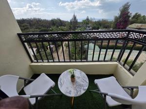 a balcony with a table and chairs on a balcony at Jay Homes -Ultra Modern Naivegas Apartments in Naivasha
