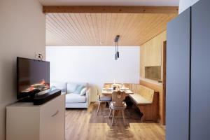 a living room with a table and a tv at Brentsch A29 in Scuol