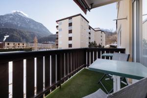 a balcony with a table and chairs and a mountain at Brentsch A29 in Scuol