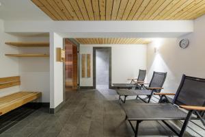 a room with chairs and tables and a clock on the wall at Brentsch A29 in Scuol