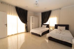 a bedroom with two beds and large windows at siriuspalaceluxor in Al Karnak +108 photos