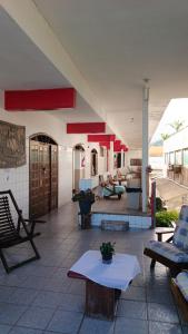 a patio with chairs and a table and a couch at Pousada Taiwan in Ubatuba