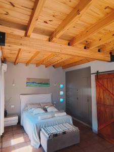 a bedroom with a large bed with a wooden ceiling at CasaVid - Private Boutique Chalet & Spa - Vistas 360 in Tafí del Valle