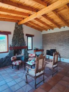 a living room with chairs and a stone fireplace at CasaVid - Private Boutique Chalet & Spa - Vistas 360 in Tafí del Valle