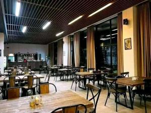 a dining room with tables and chairs and windows at Bakuriani - Didveli Gallery B212 in Bakuriani