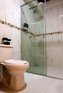 a bathroom with a toilet and a glass shower at Apartamento clásico Riosucio in Ruiosucio