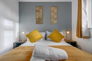 a bedroom with a large bed with yellow pillows at 4 Bedroom Family & Contractor House in Colwick, Nottingham - Sleeps 8 - By CircleWay Homes in Nottingham