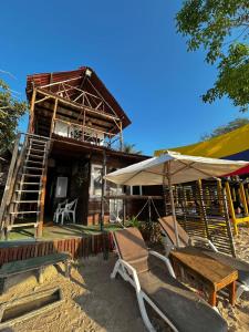 a house with chairs and an umbrella in front of it at La playita ocean view in Playa Blanca
