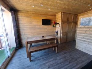 a wooden room with a table and a tv at Studio cosy 6 pers au pied des pistes et vue exceptionnelle sur les Alpes à SUPERDÉVOLUY in Le Dévoluy
