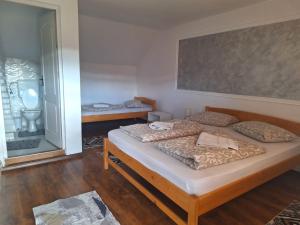 a bedroom with two beds and a large window at Rajni Panzió in Praid