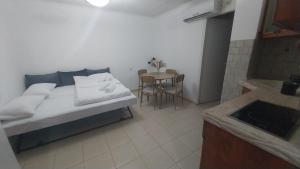 a bedroom with a bed and a table and a kitchen at גאון מול המדבר in Arad