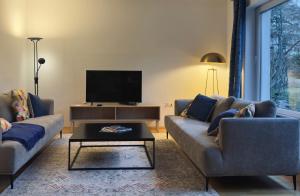 a living room with two couches and a tv at ZU HAUSE Pfalz in Bad Dürkheim