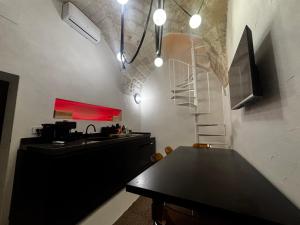 a dining room with a black table and a staircase at LEFKÓ OSTUNI, JACUZZI VISTA Mare in Ostuni