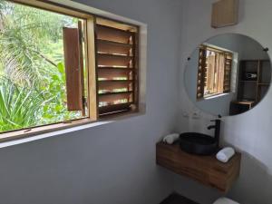 a bathroom with a mirror and a sink and a window at Moemoea Lodge in Ambatoloaka +27 photos