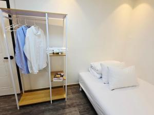 a bedroom with a closet with a white bed and white clothes at URBAN KS Stay in Seoul