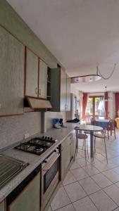 a kitchen with a stove and a table with chairs at Appartamento A Limone in Limone sul Garda