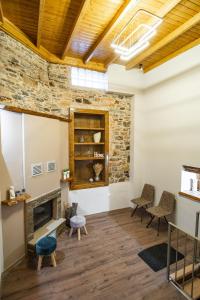 a living room with a stone fireplace and chairs at Mary's cozy apartment 2 in Pýrgos