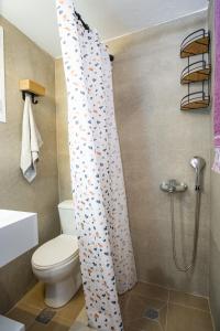 a bathroom with a toilet and a shower curtain at Mary's cozy apartment 2 in Pýrgos