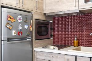 a kitchen with a refrigerator and a sink at Mary's cozy apartment 2 in Pýrgos
